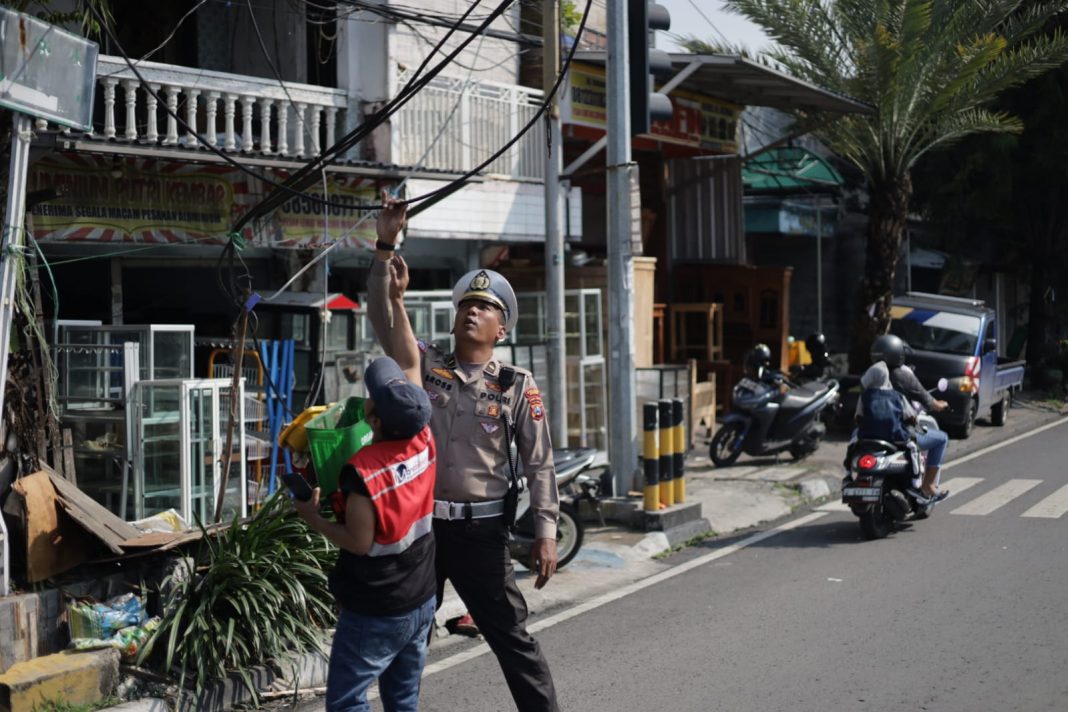 Sat Lantas Polres Gresik Sigap Tangani Putusnya Kabel Listrik di Simpang 4 Kebomas